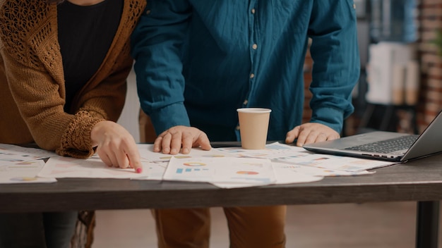 close-up-rate-charts-papers-with-analysis-information-desk-man-woman-looking-files-plan-project-presentation-startup-office-colleagues-doing-teamwork-strategy_482257-28125
