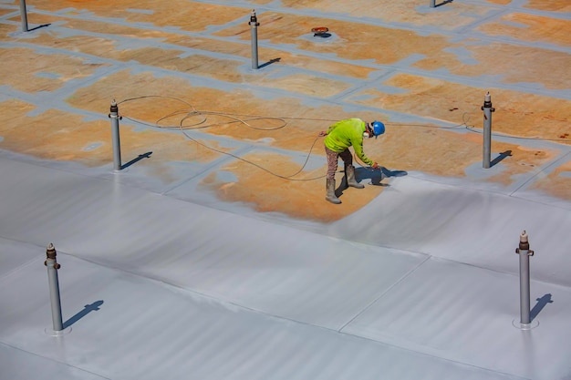 male-worker-holding-industrial-spray-gun-used-roof-plate-tank-surface-steel-industrial-painting-coating_478515-11706
