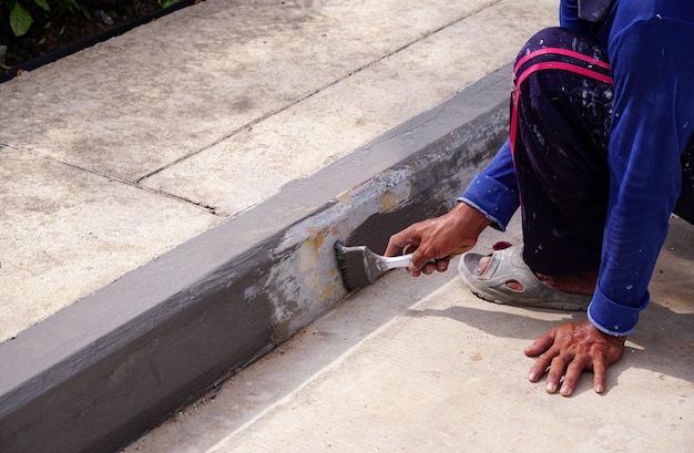 paint-edge-sidewalk-with-paint-brush-improvement-ideas-apply-primer-before-actual-pai_483511-5499