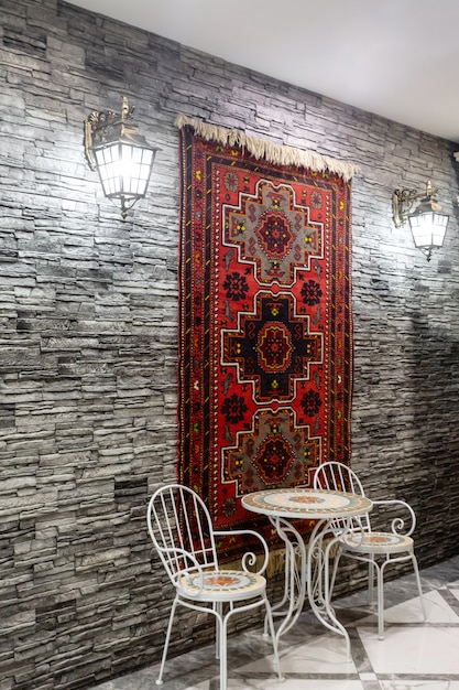 restaurant-hall-with-grey-stone-wall-decorated-with-azerbaijani-carpet_140725-8503