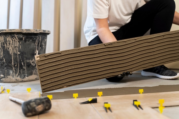 worker-tiling-floor-with-material_23-2149343999